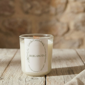 Vela de aromaterapia bergamota artesanal en vaso de cristal sobre mesa rústica