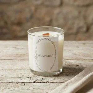 Vela artesanal de soja aroma manzanilla con mecha de madera sobre mesa rústica