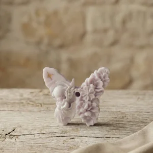 Vela decorativa artesanal de soja con forma de mariposa sobre mesa de madera rústica