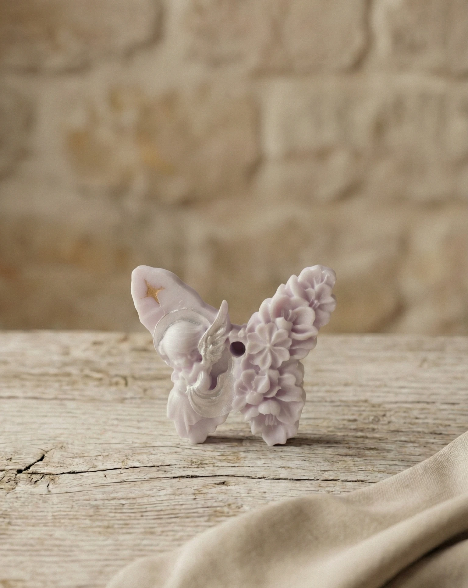 Vela decorativa artesanal de soja con forma de mariposa sobre mesa de madera rústica