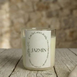 Vela artesanal de soja aroma jazmín con mecha de madera sobre mesa rústica y fondo de piedra natural