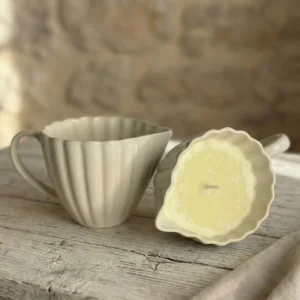 Detalle de vela de masaje Body Serum con cera derretida en tacita de cerámica