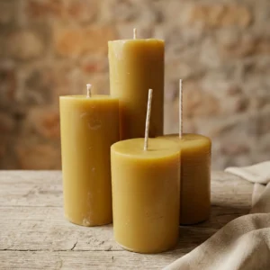 Velas pilar artesanales de cera de abeja en distintos tamaños sobre mesa de madera