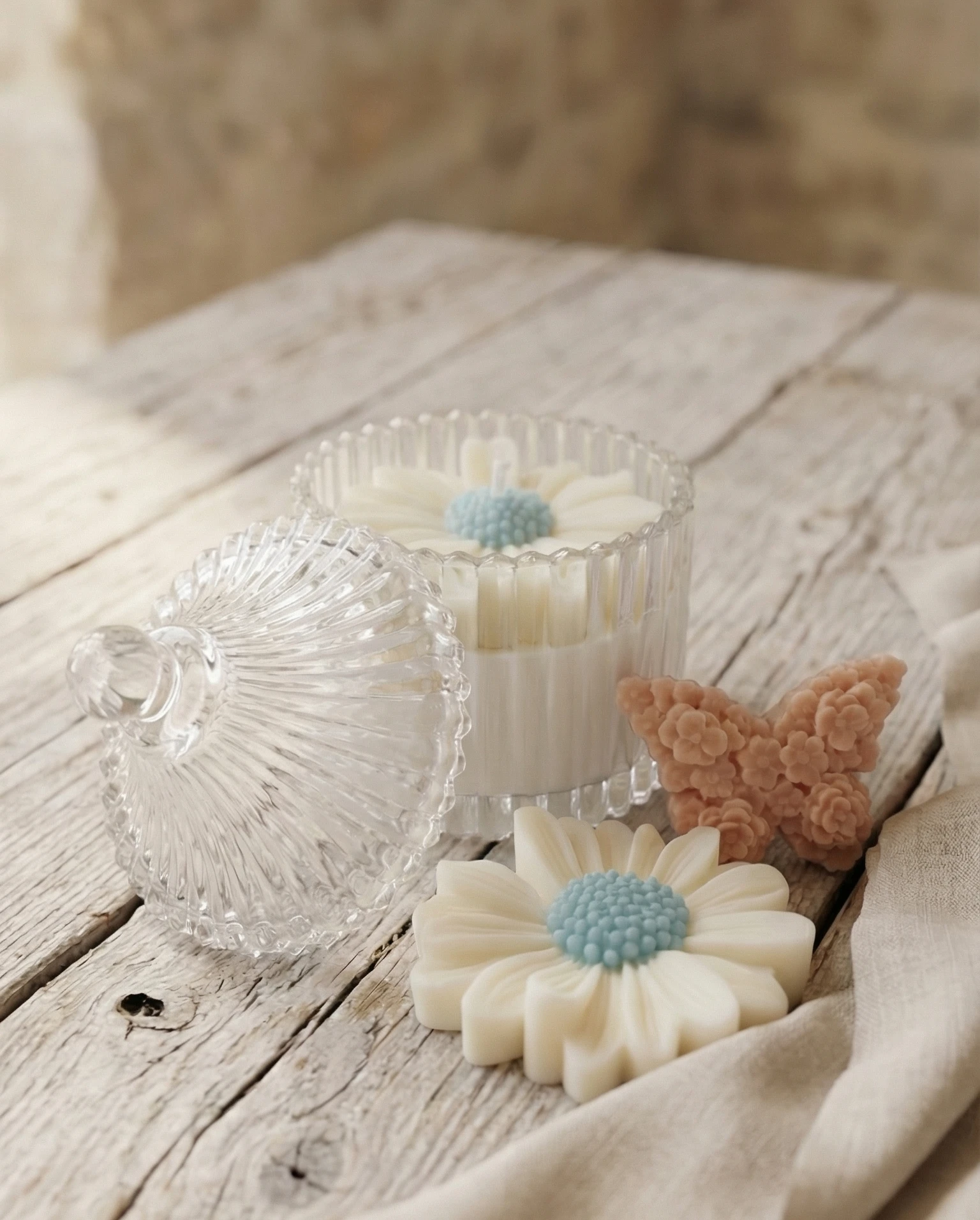 Vela bombonera de cristal con vela floral de soja en forma de margarita