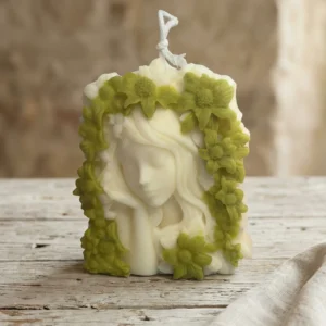 Vela de soja decorativa artesanal con rostro de mujer rodeado de flores verdes estilo primavera