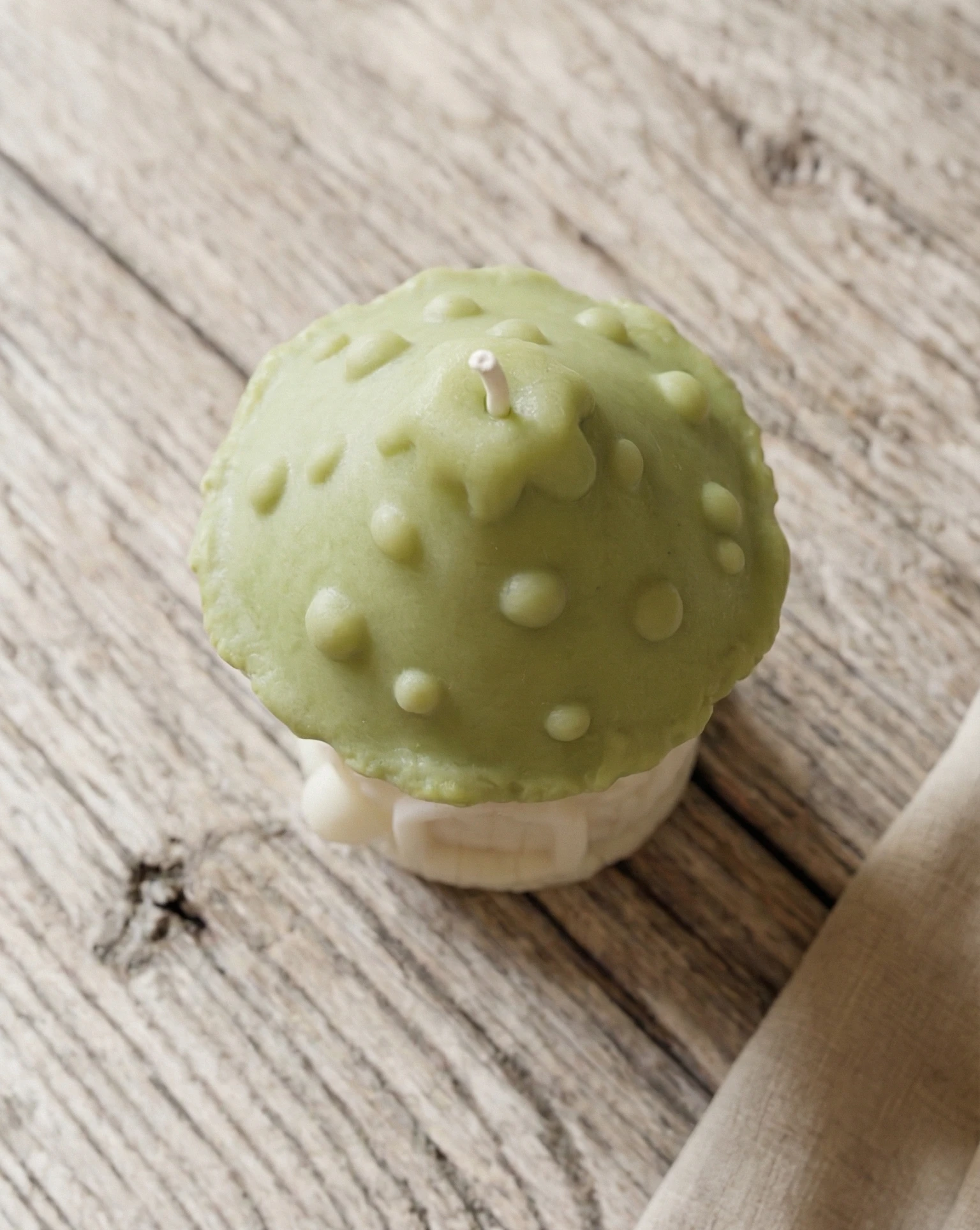 Vista superior de vela decorativa en forma de seta casita de gnomo con tejado verde