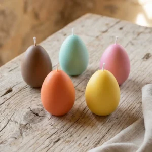 Conjunto de velas huevo de Pascua de colores sobre mesa de madera