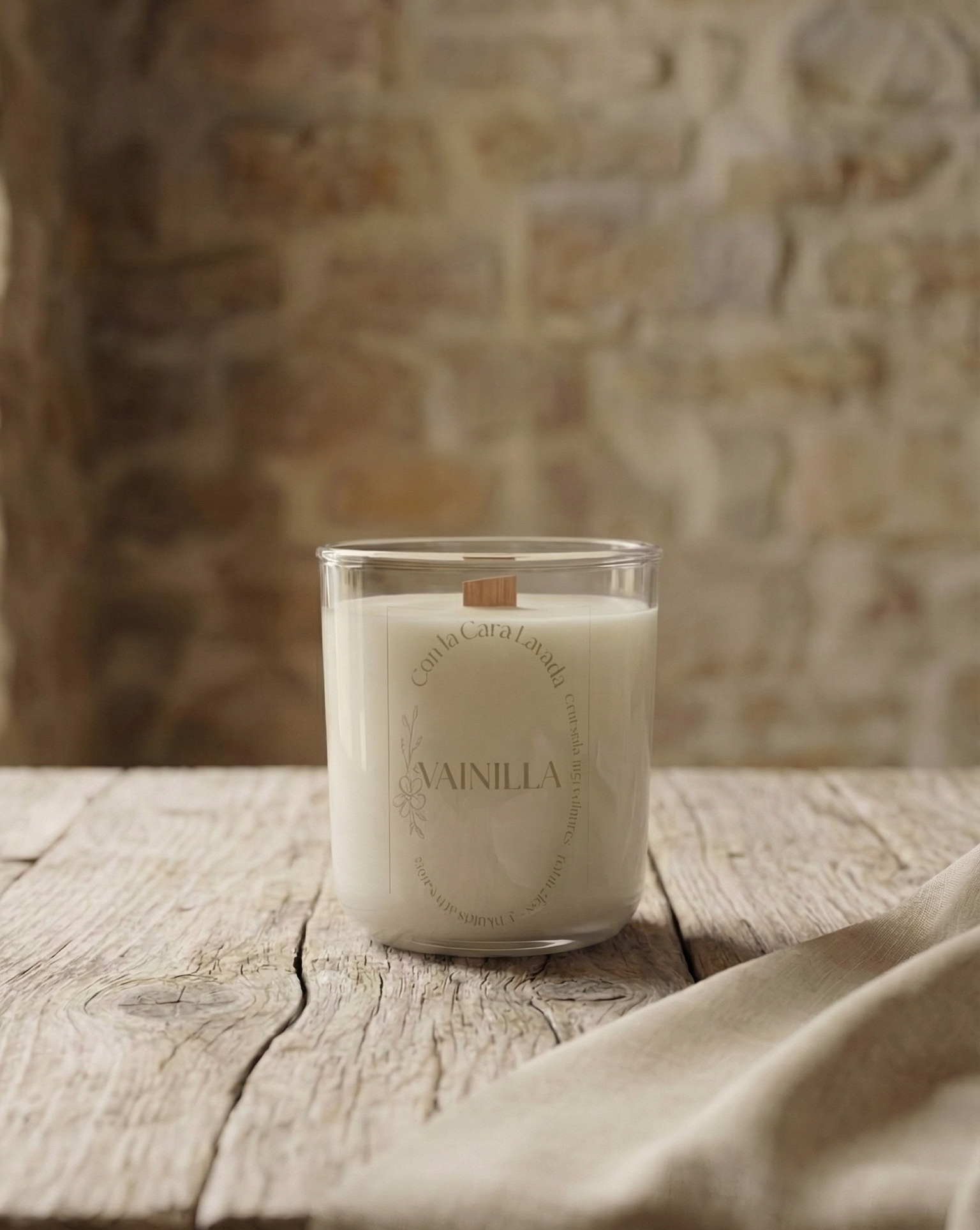 vela aromática de soja con aroma a vainilla en vaso de cristal sobre mesa de madera rústica