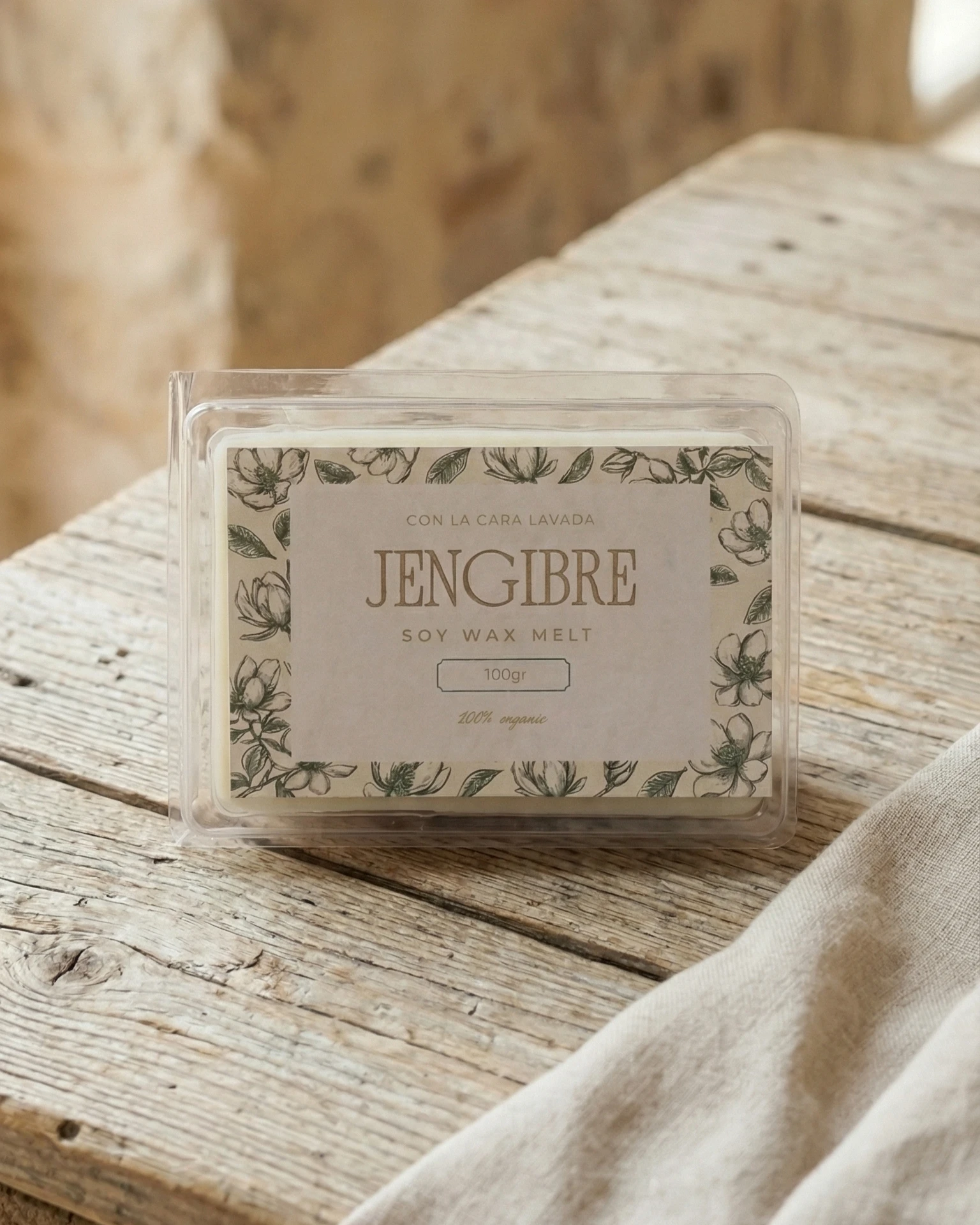 wax melt aroma jengibre en envase transparente sobre mesa de madera