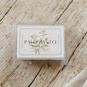 wax melt de palo santo en envase transparente sobre madera