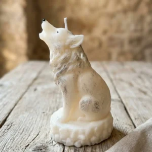 Vela decorativa de soja con forma de lobo blanco vista lateral sobre mesa de madera envejecida